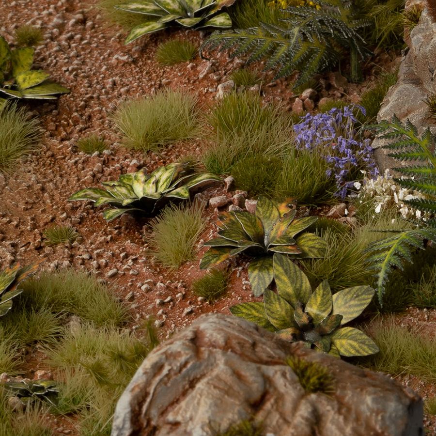 Miniature terrain featuring assembled Dumb Cane laser-cut plants integrated into a realistic scenic landscape.